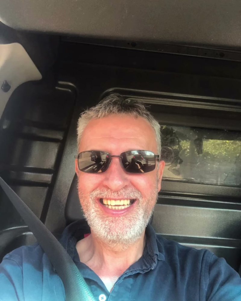 Peter from Mavis Carpet Cleaning, smiling, in the driver's seat of his van
